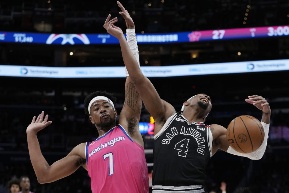 Washington Wizards guard Jordan Goodwin (7) and San Antonio Spurs guard Devonte' Graham (4) collide during the first half of an NBA basketball game Friday, March 24, 2023, in Washington. (AP Photo/Carolyn Kaster)