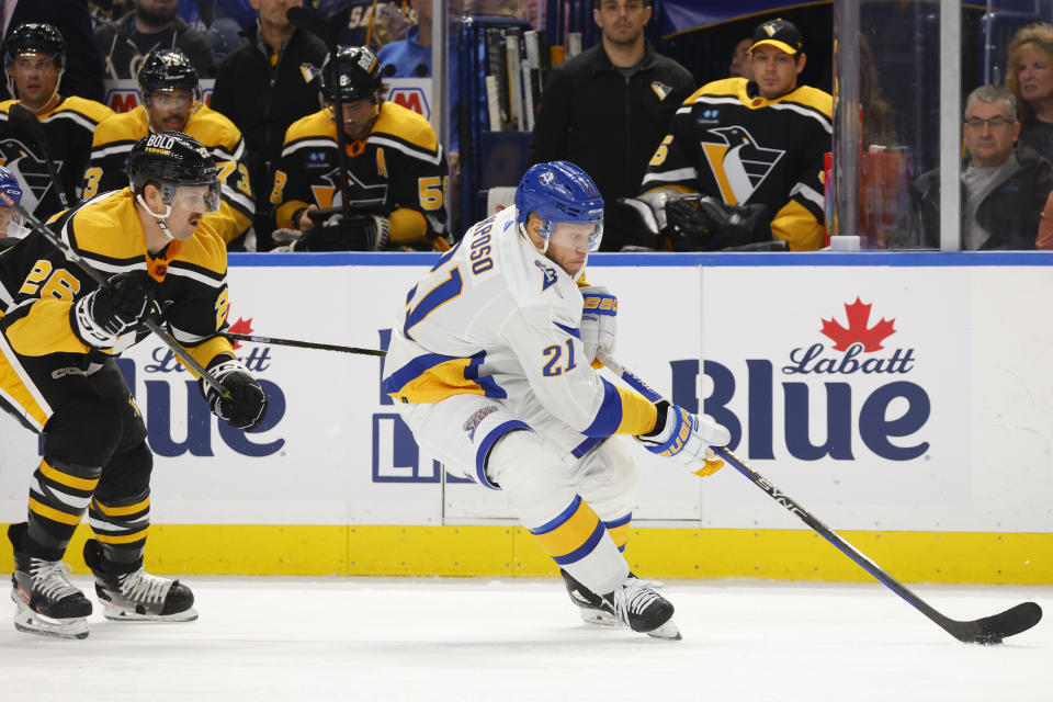 Buffalo Sabres right wing Kyle Okposo (21) carries the puck past Pittsburgh Penguins defenseman Jeff Petry (26) during the first period of an NHL hockey game Wednesday, Nov. 2, 2022, in Buffalo, N.Y. (AP Photo/Jeffrey T. Barnes)