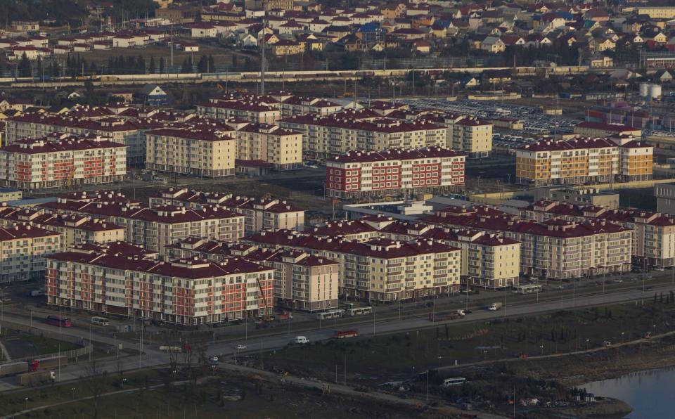 An aerial view from a helicopter shows residential houses recently constructed for the 2014 Winter Olympics in the Adler district of the Black Sea resort city of Sochi, December 23, 2013. Sochi will host the 2014 Winter Olympic Games in February. Picture taken December 23, 2013. REUTERS/Maxim Shemetov (RUSSIA - Tags: CITYSCAPE BUSINESS CONSTRUCTION SPORT OLYMPICS)