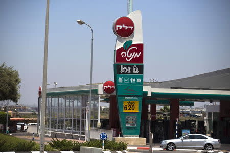 A car drives past a petrol station, that was burnt after a rocket hit it during the 2014 Gaza war, in the southern Israeli city of Ashdod, Israel, July 7, 2015. REUTERS/Amir Cohen