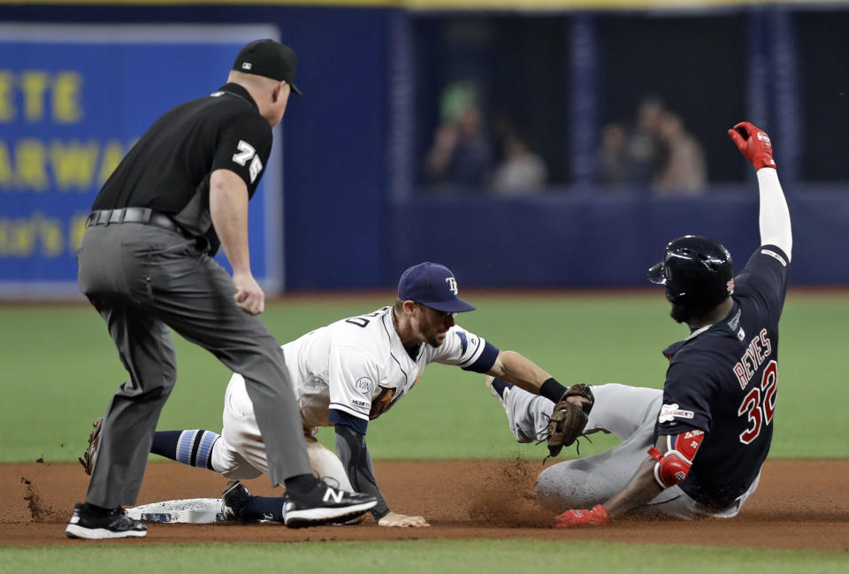 Tampa Bay Rays second baseman Eric Sogard tags out Cleveland Indians' Franmil Reyes (32), who was trying to stretch a single into a double during the fourth inning of a baseball game Saturday, Aug. 31, 2019, in St. Petersburg, Fla. Making the call is umpire Tom Woodring. (AP Photo/Chris O'Meara)