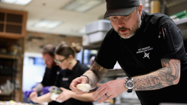 Shaun O'Neale making food at a culinary event.