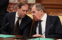 Russian Minister of Industry and Trade Denis Manturov talks to Foreign Minister Sergei Lavrov during a government meeting in Moscow