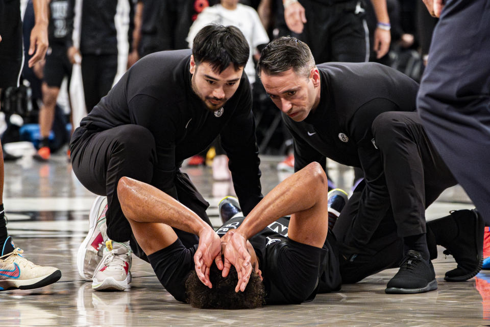 Brooklyn Nets forward Cameron Johnson receives attention from team staff during the second half of an NBA basketball game against the Oklahoma City Thunder in New York, Friday, Jan. 5, 2024. (AP Photo/Peter K. Afriyie)