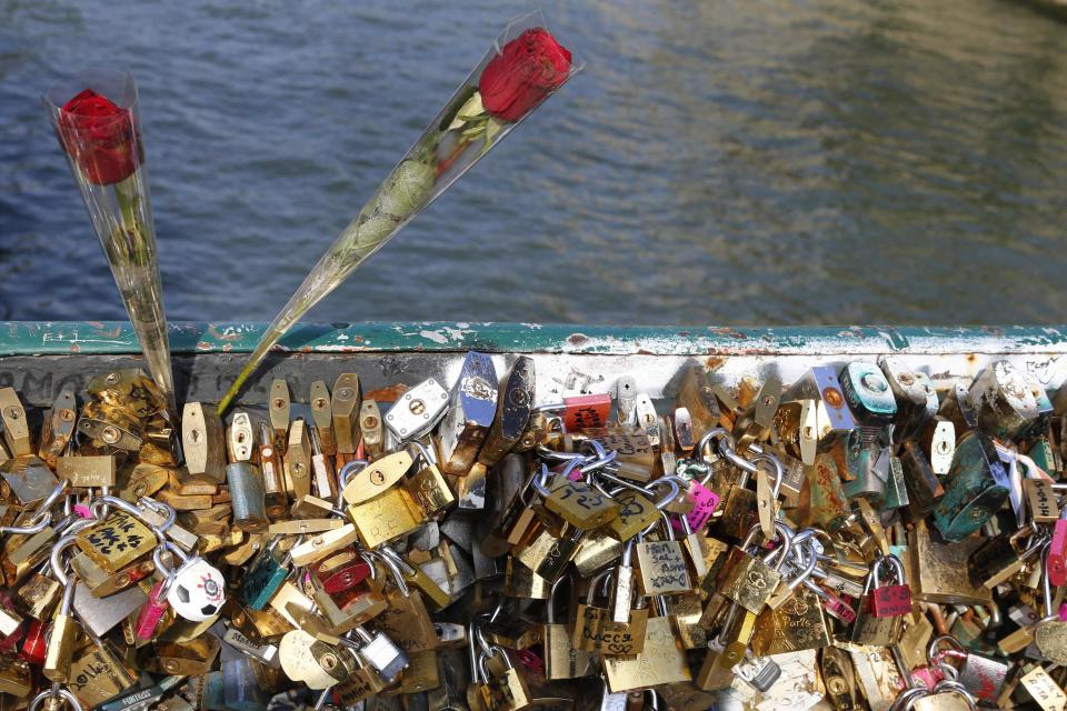 Two roses and padlocks clipped by lovers are seen on the Pont de l'Archeveche bridge, near the Notre Dame Cathedral in Paris September 23, 2014. (REUTERS/Jacky Naegelen)