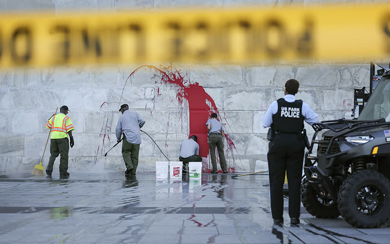 U.S. Park Service employees remove graffiti on the Washington Monument