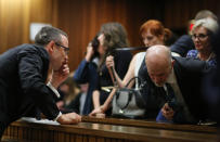 Oscar Pistorius, left, talks with his uncle Arnold Pistorius, right, during his ongoing murder trial in Pretoria, South Africa, Tuesday, May 13, 2014. Pistorius is charged with the shooting death of his girlfriend Reeva Steenkamp on Valentine's Day in 2013. (AP Photo/Themba Hdebe, Pool)