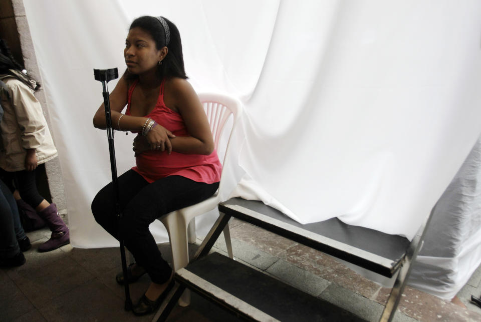 In this Feb. 5, 2013 photo, Diana Armijos, of Ecuador, waits to get her make-up applied before modeling in the Bionic Fashion show, backstage at the Metropolitan Cultural Center in Quito, Ecuador. Armijos, a cancer survivor whose leg was amputated due to her illness, is in her last week of pregnancy. She joined 15 other models from Argentina, Brazil, Bolivia, Costa Rica, Colombia and Venezuela to model creations by Ecuadorian designers at an event organized by the Youth Against Cancer Foundation which aimed to break stereotypes and social barriers for the young cancer survivors. (AP Photo/Dolores Ochoa)