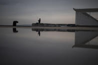 FILE - In this Jan. 10, 2021 file photo, a fisherman reels in his line before a curfew is enforced in Marseille, southern France. Trying to fend off the need for a third nationwide lockdown that would further dent Europe’s second-largest economy and put more jobs in danger, France is instead opting for creeping curfews. (AP Photo/Daniel Cole, File)