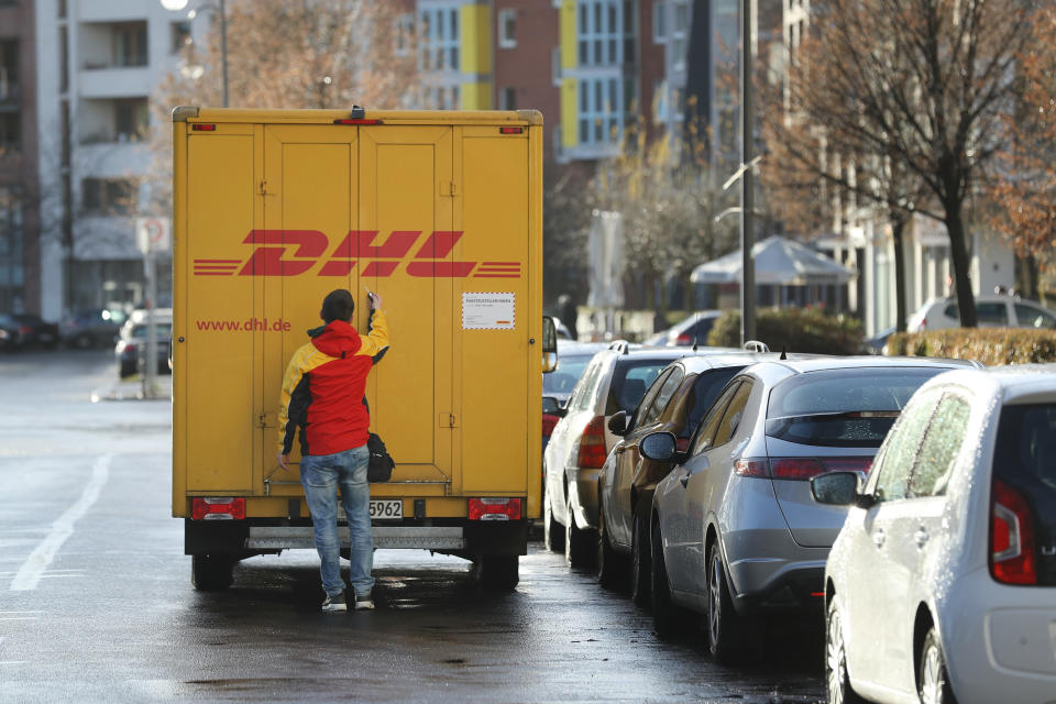 BERLIN, GERMANY - DECEMBER 04:  An employee of package delivery service DHL opens the door of a DHL truck on December 4, 2017 in Berlin, Germany. DHL, which belongs to German postal carrier Deutsche Post, is currently the target of a blackmailer. According to police the blackmailer sent two recent packages, one delivered to a pharmacy in Potsdam last Friday and one delivered in November in Frankfurt an der Oder. The one sent to Potsdam contained a very large firecracker and nails and, according to a recent police announcement, could have detonated. The blackmailer is reportedly demanding at least EUR 1 million and is threatening to send more explosive-laden packages.  (Photo by Sean Gallup/Getty Images)