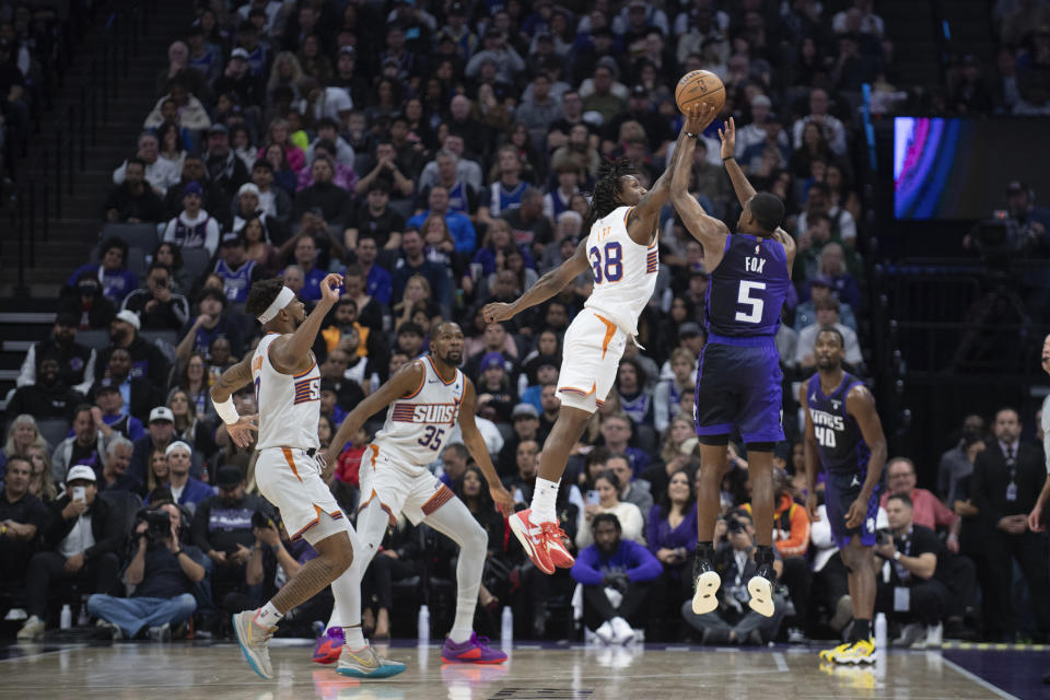 Phoenix Suns guard Saben Lee (38) blocks a shot attempt by Sacramento Kings guard De'Aaron Fox (5) during the first quarter of an NBA basketball game in Sacramento, Calif., Friday, Dec. 22, 2023. (AP Photo/José Luis Villegas)