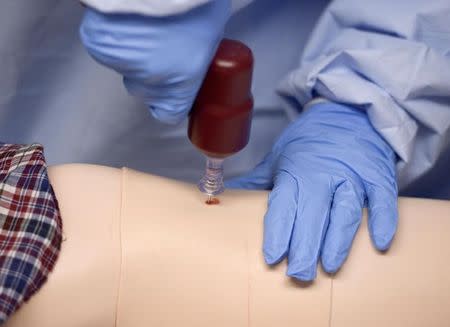 A participant practises a medical procedure on a dummy during training for the Ebola response team at Fort Sam Houston in San Antonio, Texas October 24, 2014. REUTERS/Darren Abate