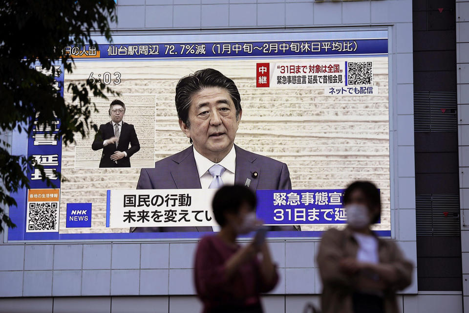 A huge monitor shows Japanese Prime Minister Shinzo Abe's press conference, in Tokyo Monday, May 4, 2020. Abe announced Monday that the ongoing coronavirus state of emergency will be extended for about a month until the end of May. (Koji Harada/Kyodo News via AP)