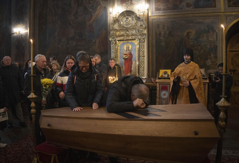 Dos padres de familia lloran sobre el ataúd de Oleksandr Grianyk del regimiento Azov a quien mataron el 8 de mayo defendiendo la ciudad de Mariúpol de los invasores rusos, durante un funeral en la Catedral de San Miguel en Kyiv, Ucrania, el 14 de enero de 2023. Los restos de Grianyk fueron identificados recientemente. (Foto AP/Efrem Lukatsky)