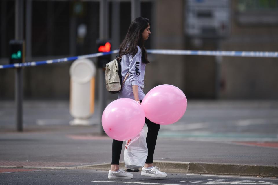 A girl wearing a t-shirt of US singer Ariana Grande carrying balloons from the Ariana Grande concert at the Manchester Arena.&nbsp;