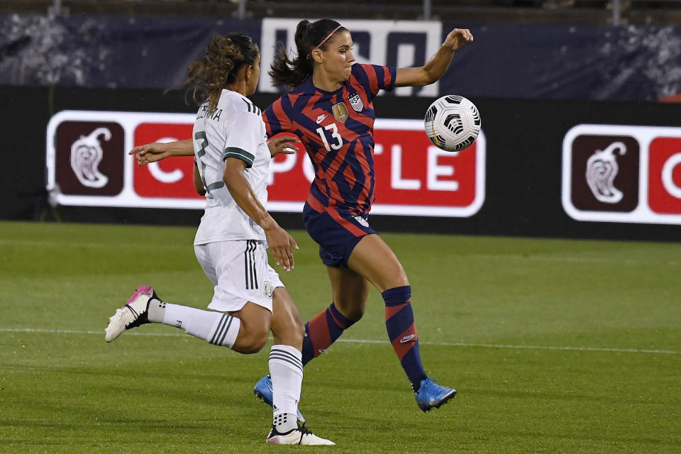 United States' Alex Morgan, right, takes a shot on goal as Mexico's Bianca Sierra, left, defends during the first half of an international friendly soccer match, Thursday, July 1, 2021, in East Hartford, Conn. (AP Photo/Jessica Hill)