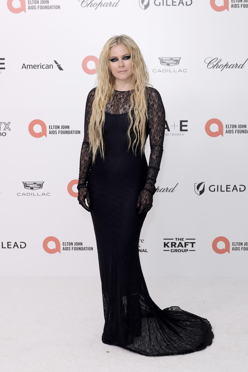 Avril Lavigne in black lace dress by Vetements with built in black gloves. 