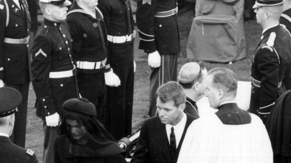 Jackie Kennedy walks away from the gravesite of her husband John F. Kennedy November 25, 1963 at Arlington Cemetary. Robert Kennedy is at her side