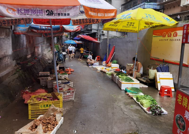 Vendors sell vegetables at street stalls, in Guangzhou's Xiaobei neighborhood