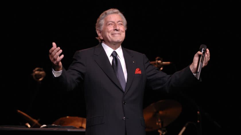 Tony Bennett outstretching his arms onstage