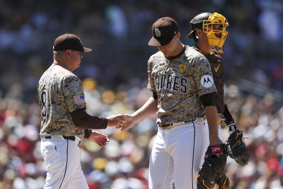 San Diego Padres manager Mike Shildt, left, takes the ball from starting pitcher Michael King, front right, during a pitching change in the sixth inning against the Philadelphia Phillies, Sunday, April 28, 2024, in San Diego. (AP Photo/Brandon Sloter)