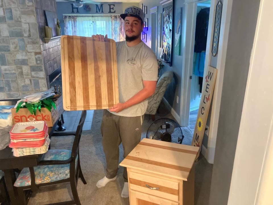 Ryan Prendergast, 17, with cutting board and nightstand he made as a fine woodworking student at Bucks County Technical High School. “We have to learn not only how to read blueprints, but draw blueprints. There’s a whole technical end (to be mastered) before the creative part kicks in.”