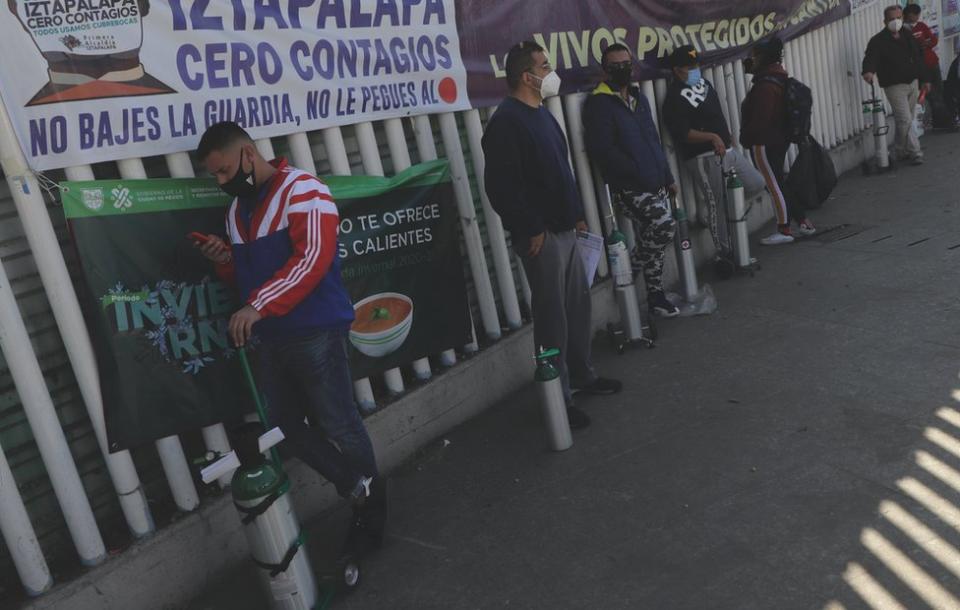 Fila de personas para llenar tanques de oxígeno.