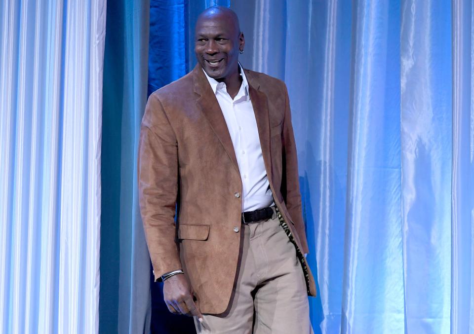 Michael Jordan looks stunning in brown leather suit and light brown pant to match.