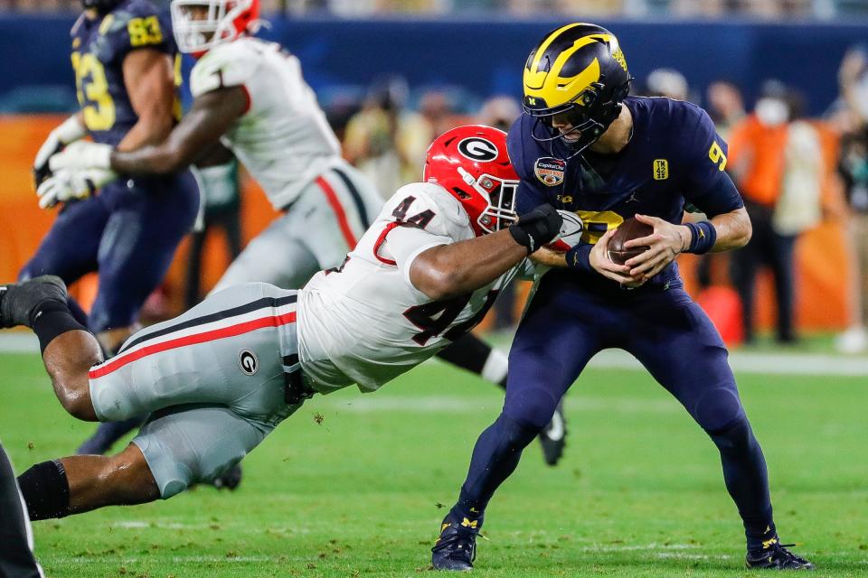 Michigan quarterback J.J. McCarthy (9) is tackled by Georgia defensive lineman Travon Walker (44) during the second half of the Orange Bowl at Hard Rock Stadium in Miami Gardens, Florida, on Friday, Dec. 31, 2021.