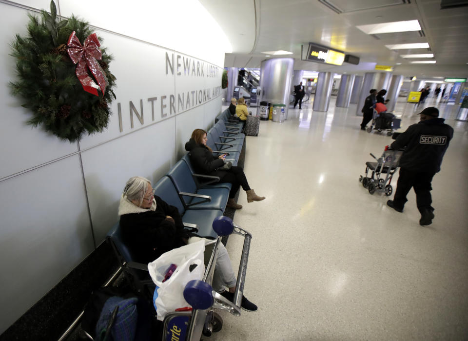 People wait near the baggage claim area at Terminal B at Newark Liberty International Airport, Tuesday, Nov. 21, 2017, in Newark, N.J. Early holiday travel has picked up at the airport with travelers flying on Tuesday ahead of the Thanksgiving Day holiday. (AP Photo/Julio Cortez)