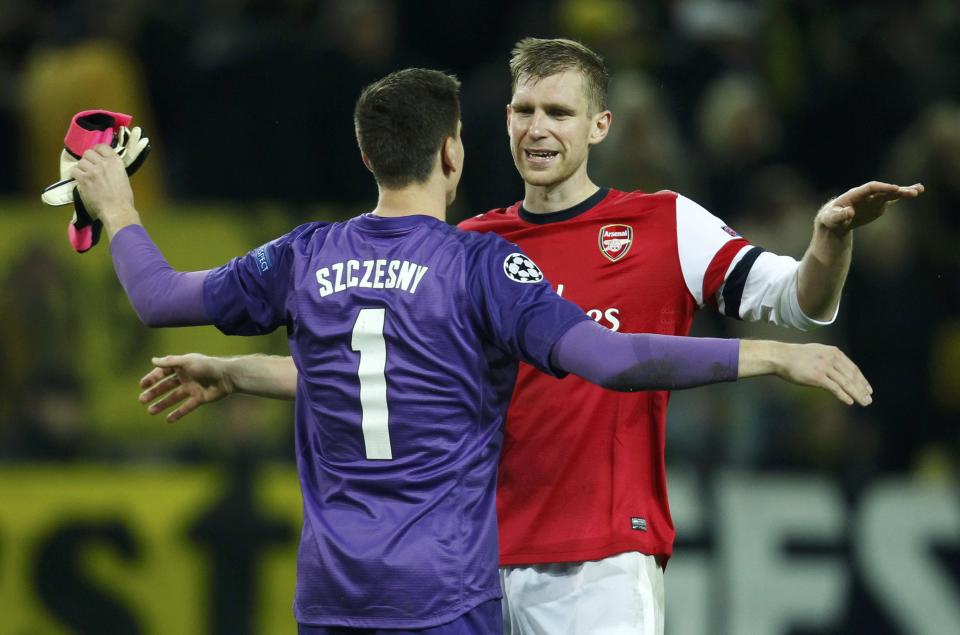 Arsenal's goalkeeper Wojciech Szczesny and team mate Per Mertesacker (R) celebrate after defeating Borussia Dortmund in their Champions League Group F soccer match in Dortmund November 6, 2013. REUTERS/Ina Fassbender (GERMANY - Tags: SPORT SOCCER)