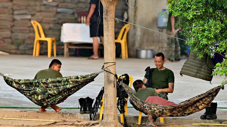 Members of a Myanmar militia rest beside the Moei river near the Thai border on April 11, 2024. - Manan Vatsyayana/AFP/Getty Images