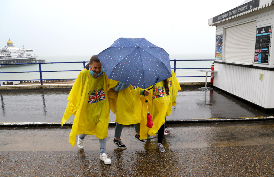 German exchange students brave torrential rain on the promenade in Eastbourne, Sussex (Picture: PA)