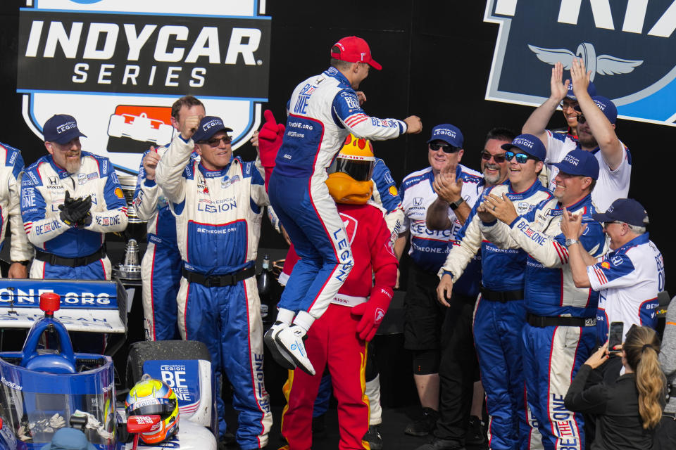 Alex Palou, of Spain, jumps off his car to his crew as he celebrates winning the IndyCar auto race at Indianapolis Motor Speedway in Indianapolis, Saturday, May 13, 2023. (AP Photo/Michael Conroy)