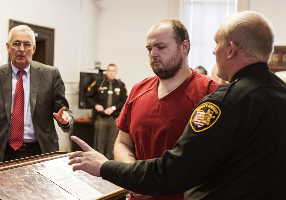 FILE—In this file photo from Nov. 28, 2018, George Wagner IV, center, is escorted out of the courtroom after his arraignment at the Pike County Courthouse, in Waverly, Ohio. Wagner, his parents and brother were charged in the 2016 shootings of eight members of the Rhoden family. Ohio Judge Randy Deering on Wednesday Dec. 22, 2021, denied a request by lawyers for Wagner to dismiss his aggravated murder charges, thereby keeping the death penalty on the table for the man accused in the slayings of eight people from a single family. The lawyers said Wagner's brother, who pleaded guilty this year in the shootings, admitted to killing five of the victims and that George Wagner IV didn't kill anyone.(Robert McGraw//The Chillicothe Gazette via AP, Pool, File)