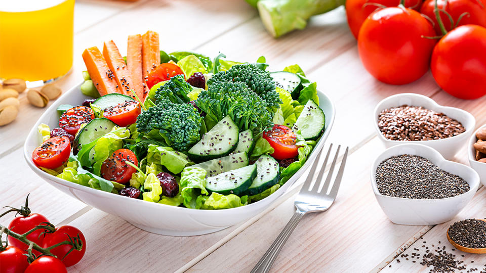 Plate of salad with broccoli, cucumber, tomatoes and carrots topped with chia seeds