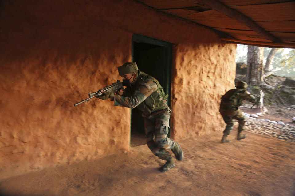 Indian army soldiers display a cordon and search operation (CASO) during a training session at a corps battle school at Sarol in Rajouri, about 135 kilometers (84 miles) northwest of Jammu, India, Tuesday, Dec. 15, 2020. AP journalists were recently allowed to cover Indian army counterinsurgency drills in Poonch and Rajouri districts along the Line of Control. The training focused on tactical exercises, battle drills, firing practice, counterinsurgency operations and acclimatization of soldiers to the harsh weather conditions. (AP Photo/Channi Anand)