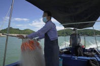 Fishermen Ng Koon-hee, right, and his brother Ng Koon-yau sail a boat in Tai O village of Hong Kong, Saturday, June 25, 2022. The Ng brothers, fishermen living in the remote Hong Kong village of Tai O, have carried on with their lives since moving from the Chinese mainland in the 1950s, untouched by political campaigns and even Britain's handover of the city to Chinese control in 1997. (AP Photo/Kin Cheung)