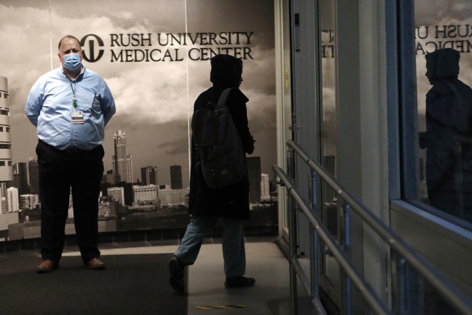 In this Wednesday, April 22, 2020, RUSH Hospital respiratory therapist Jumana Azam accesses a walkway to the hospital before starting her early morning shift in Chicago. (AP Photo/Charles Rex Arbogast)