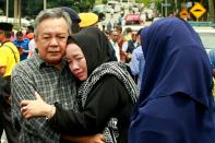 <p>Nik Azlan Nik Abdul Kadir (L), father of one of the victims comforts his wife outside the Darul Quran Ittifaqiyah religious school in Kuala Lumpur on Sept. 14, 2017. (Photo: Sadiq Asyraf/AFP/Getty Images) </p>