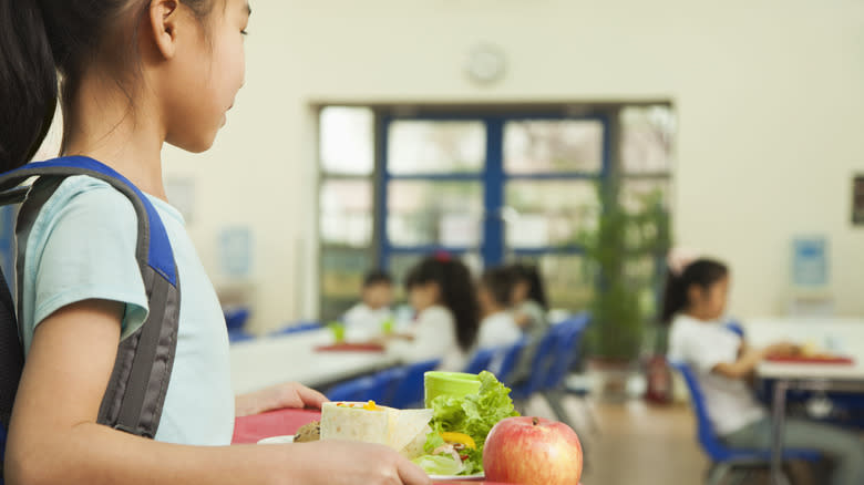 girl holding tray with healthy lunch