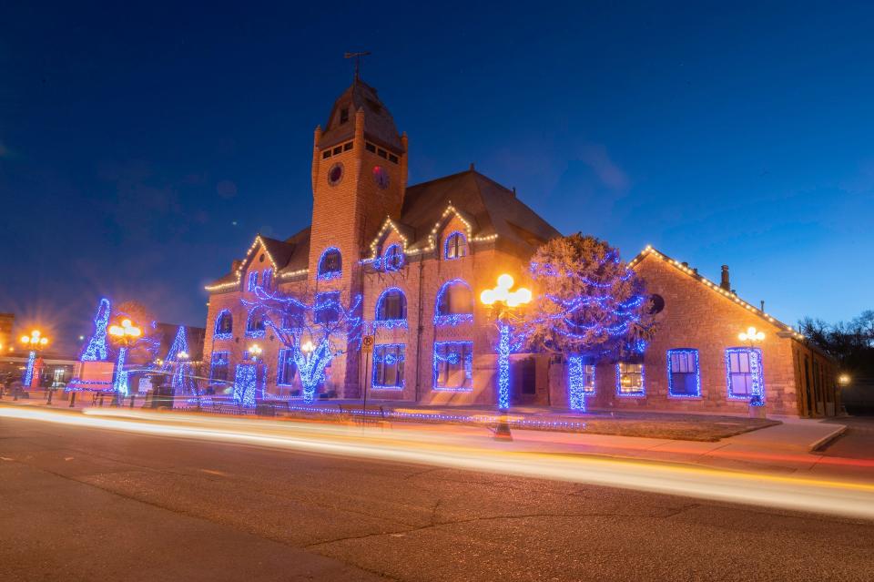 Vehicles travel by the Pueblo Union Depot during a holiday light display in December 2022.
