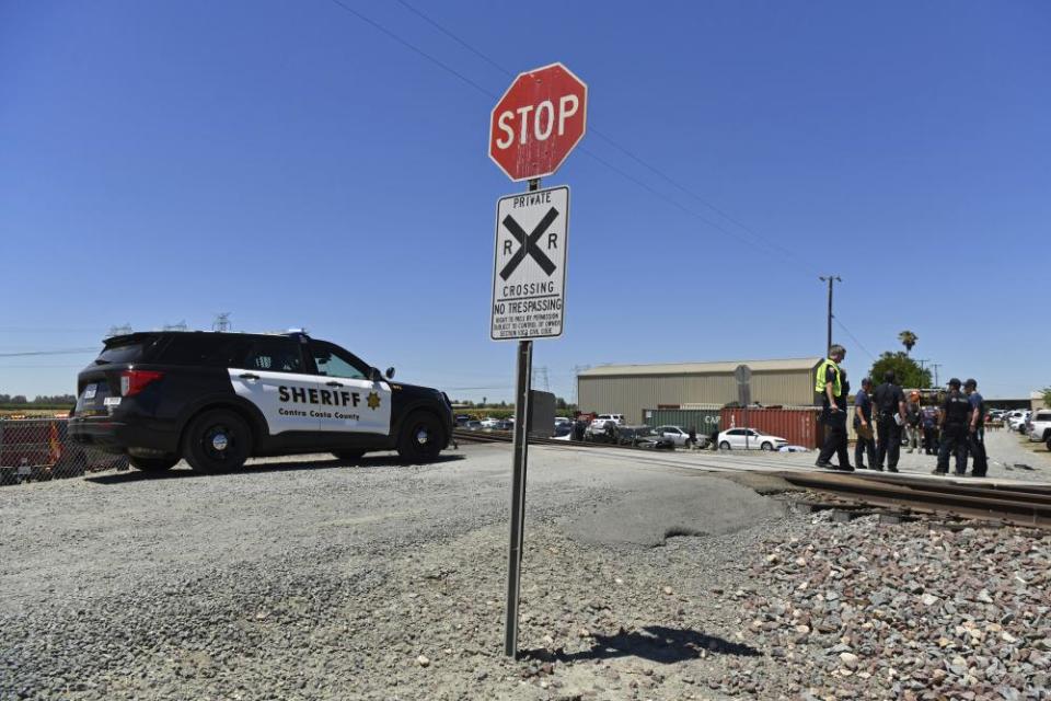 A black and white SUV marked ‘Sheriff’ sits next to train tracks in a rural area. A stop sign in front of the tracks warns of the ‘private crossing’.