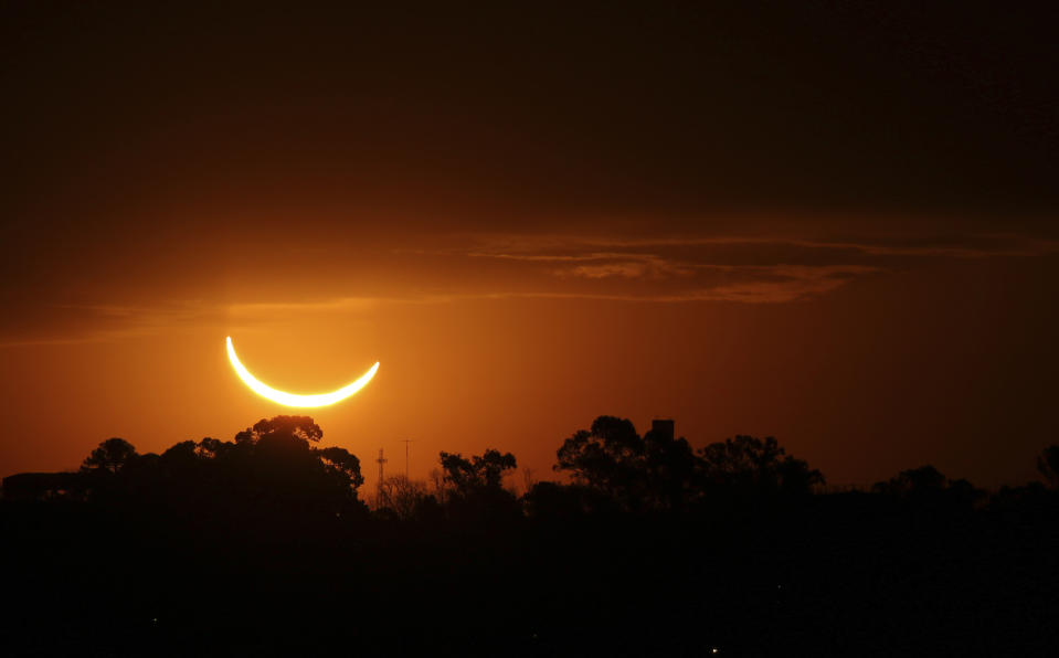 The moon passes in front of the setting sun during a total solar eclipse in Buenos Aires, Argentina, Tuesday, July 2, 2019. A solar eclipse occurs when the moon passes between the Earth and the sun and scores a bull's-eye by completely blocking out the sunlight. (AP Photo/Marcos Brindicci)