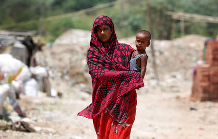 A woman from the Rohingya community walks through a camp in Delhi, India August 17, 2017. REUTERS/Cathal McNaughton