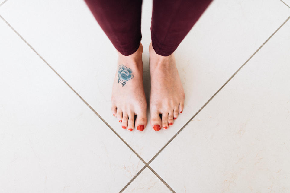 a pair of feet with a tattoo on one of them