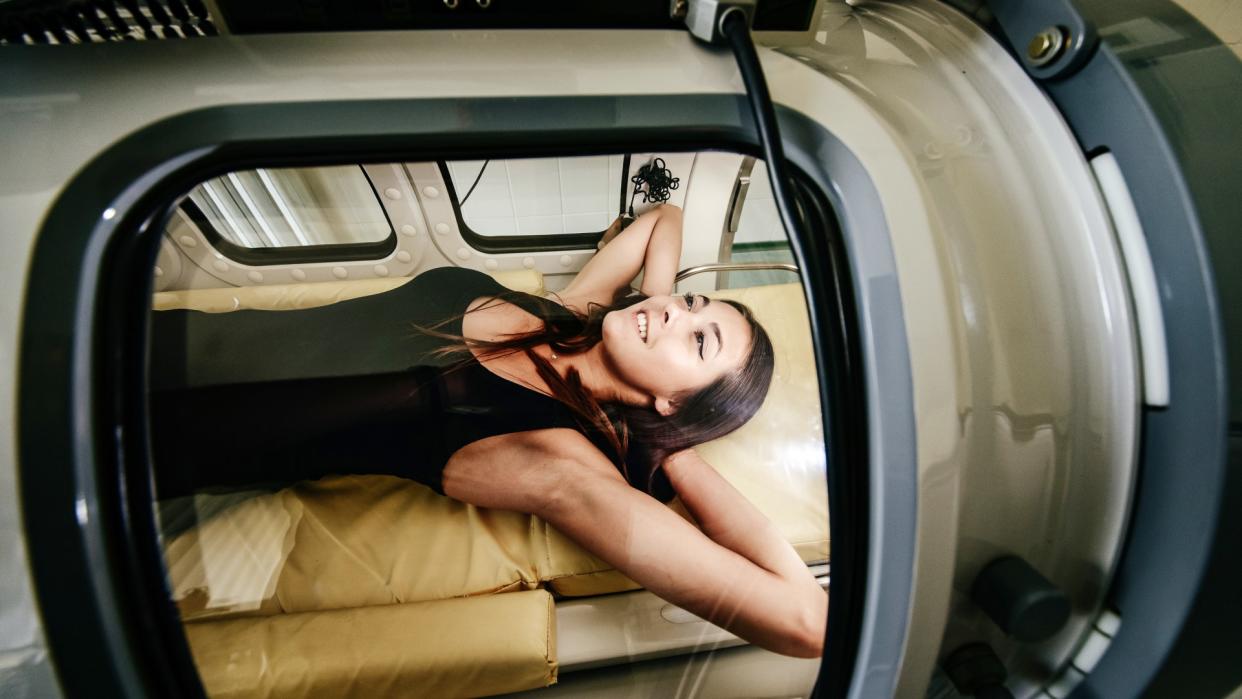  Woman laying smiling in a hyperbaric oxygen therapy chamber. 