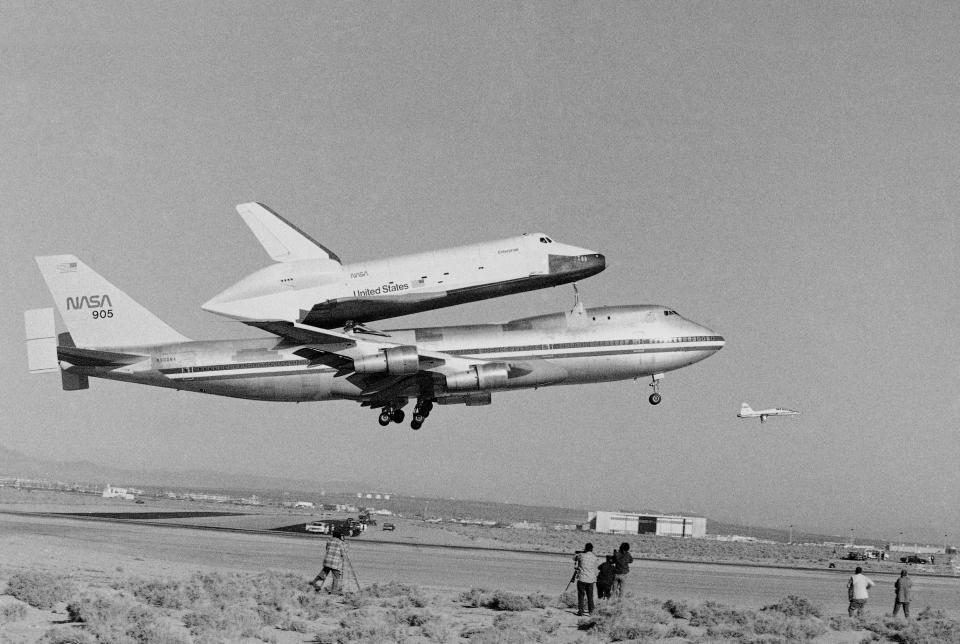 FILE - In this Feb. 18, 1977 file photo, America’s Space Shuttle Enterprise, rides atop a giant 747 on its first test flight at Edwards Air Force Base, Calif. Enterprise is scheduled to arrive in New York on the back of a NASA jumbo jet on Friday, April 27, 2012, where it will be stored in an hangar at John F. Kennedy International Airport before assuming its new permanent location on the deck of the Intrepid Air and Space Museum in New York Harbor. (AP Photo)