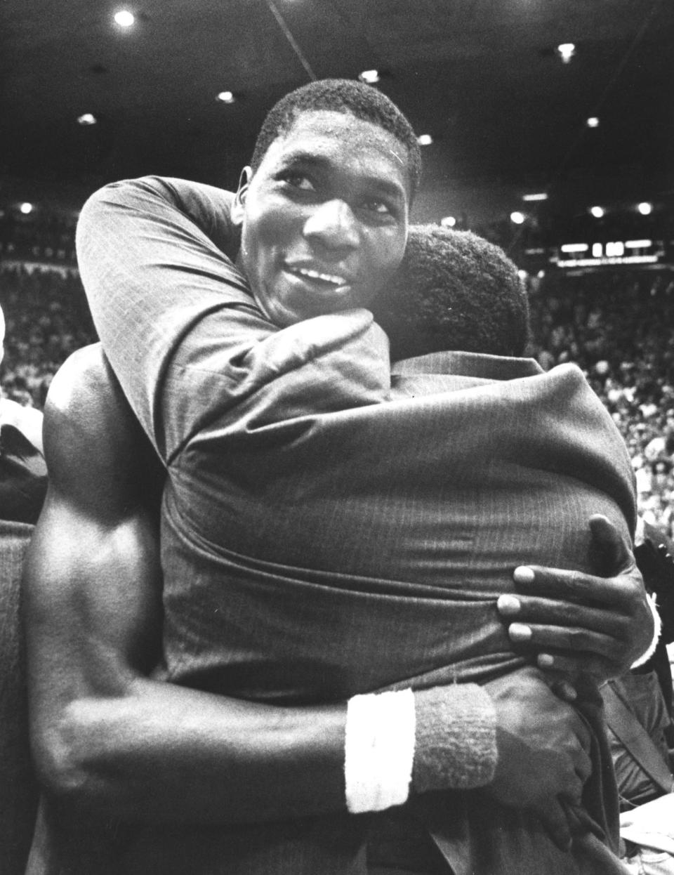 FILE - Hakeem Olajuwon gets congratulations from a Houston assistant coach after they won the semifinals, Saturday, April 2, 1983.(Larry Reese/Houston Chronicle via AP, File)