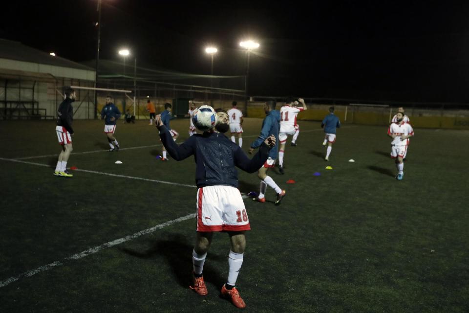 In this Sunday, Feb. 5, 2017, a player of Hope Refugee Football Club controls the ball before a soccer match in western Athens. Former Greek national soccer team goalkeeper Antonis Nikopolidis, who became a national hero in 2004 during the European Cup, is heading a project to help refugees stranded in Greece regain a sense of purpose, working as a team. On Sundays they play in an amateur league against teams made up of professional groups like lawyers, telecom workers, and accountants. (AP Photo/Thanassis Stavrakis)